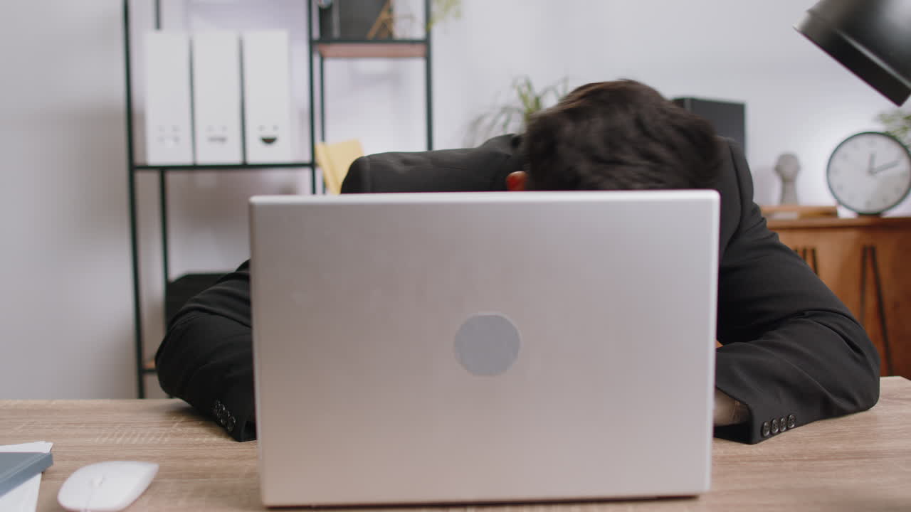 Office businessman hiding behind laptop computer making funny silly face fooling around disrespect