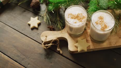 video of cups of hot chocolate with cinnamon over wooden background