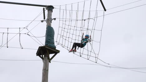 young girl on a high zip wire in the forest