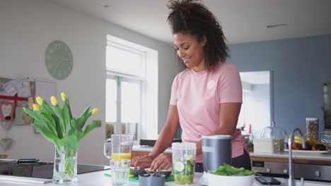 Mujer-Haciendo-Jugo-Saludable-Con-Ingredientes-Frescos-En-Un-Exprimidor-Eléctrico-Después-Del-Ejercicio.