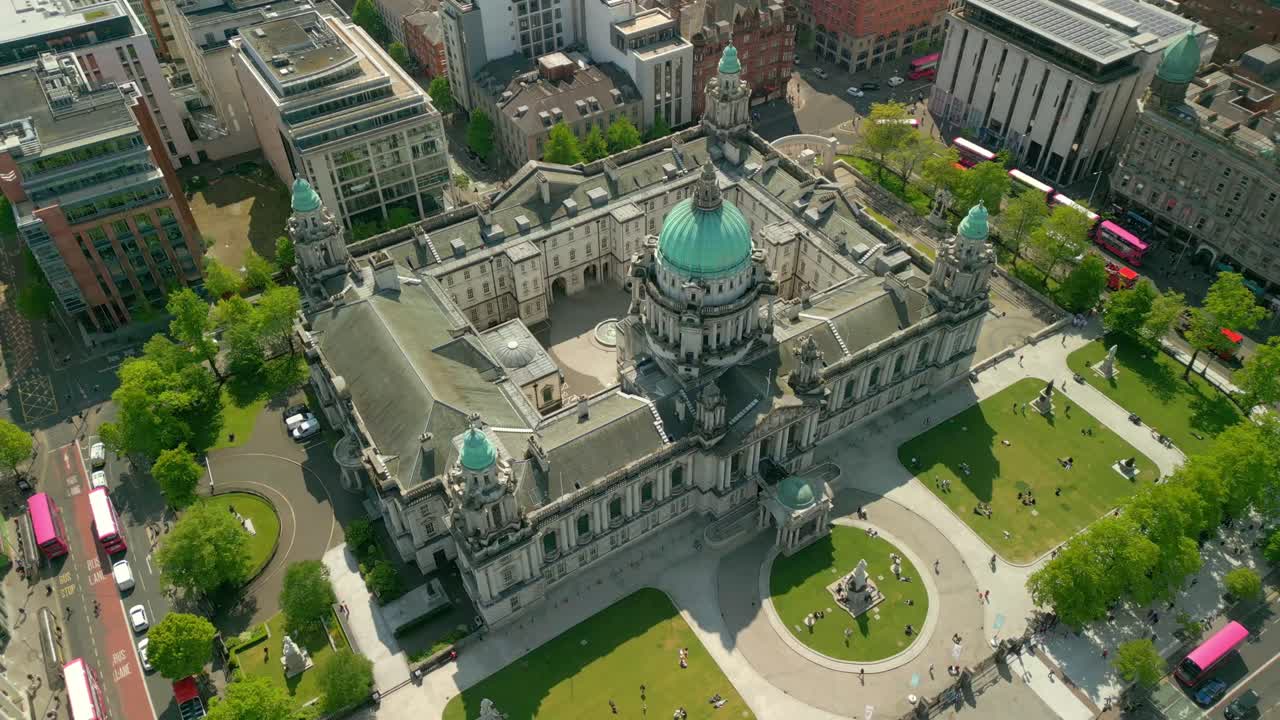 Overhead, right-to-left travelling aerial video of Belfast City Hall in Belfast, Northern Ireland, UK on a bright and sunny day. Filmed in 4K, 60FPS and with Rec709 Color.