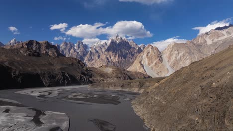 drone flying away from beautiful passu cones mountains, hunza river