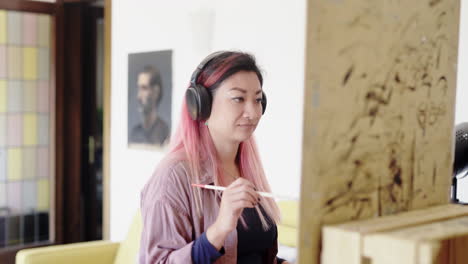 vibrando con auriculares de música mientras pinta un lienzo coreano