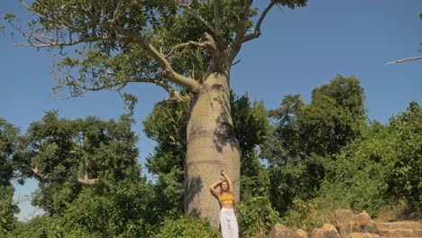 girl leaning its back on swollen trunk of boab tree at langford island in qld, australia