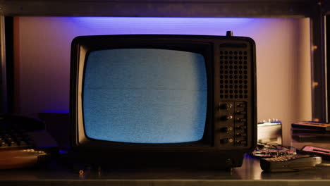 a retro tv displaying static noise, creating a nostalgic vintage atmosphere with blue and green hues.