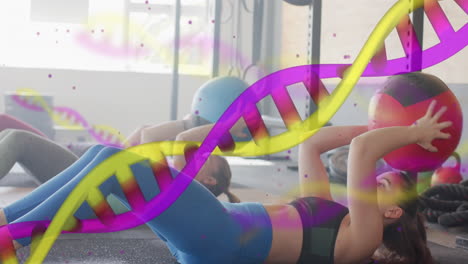 Animación-De-Hebras-De-ADN-Sobre-Diversas-Mujeres-Entrenando-Con-Balones-Medicinales-En-El-Gimnasio.