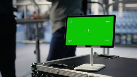 close up of green screen tablet in front of data center engineers improving rigs
