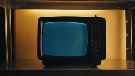 a retro tv displaying static noise, creating a nostalgic vintage atmosphere with blue and green hues.