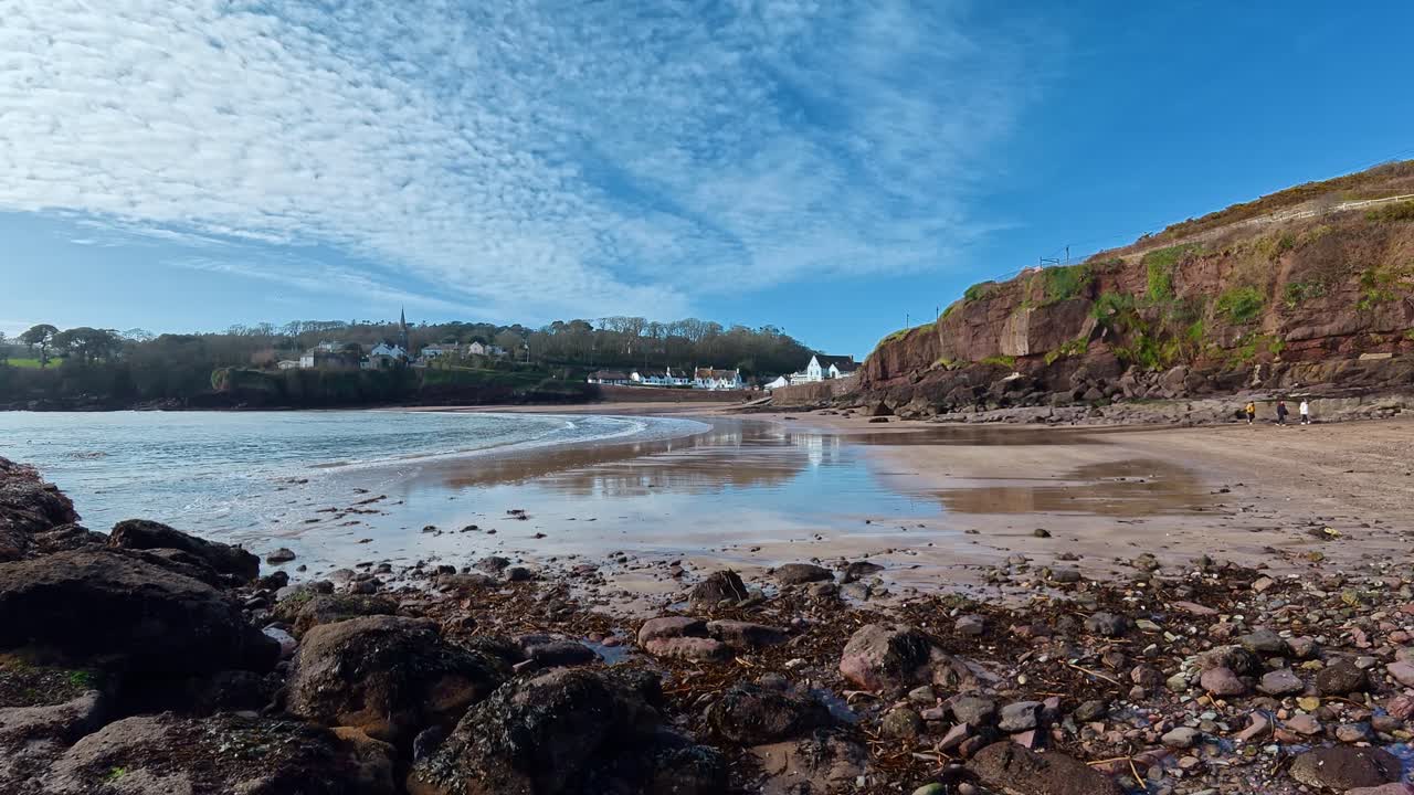 Pessoas da vila de Dunmore East explorando praia rochosa na maré baixa no início da primavera, Waterford, Irlanda. Locais épicos.