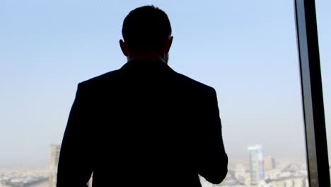 businessman looking out of a high-rise window