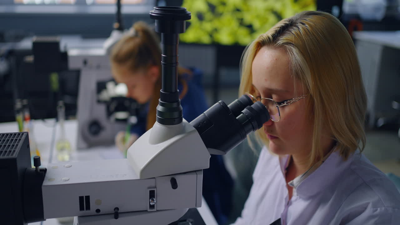 Students observing samples using microscopes in a laboratory setting