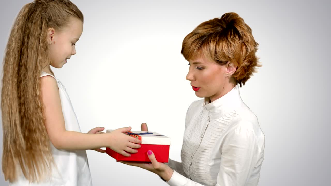 아름다운 백인 여성이  바탕에 딸으로부터 크리스마스 선물을 받습니다.