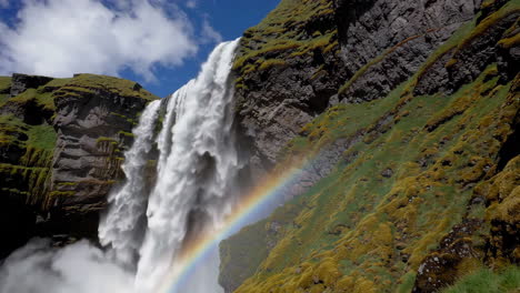 majestic waterfall with rainbow in a lush green landscape