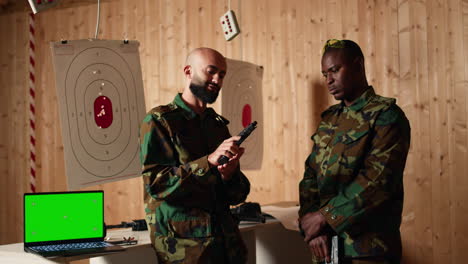 laptop de maqueta al lado de los soldados en el campo de tiro de entrenamiento con armas