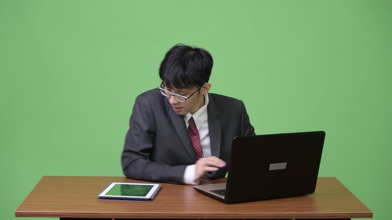 젊은 아시아 사업가 노트북과 태블릿으로 멀티 태스킹