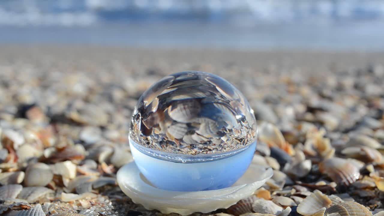 Shooting through a crystal sphere. Shooting on the sea beach