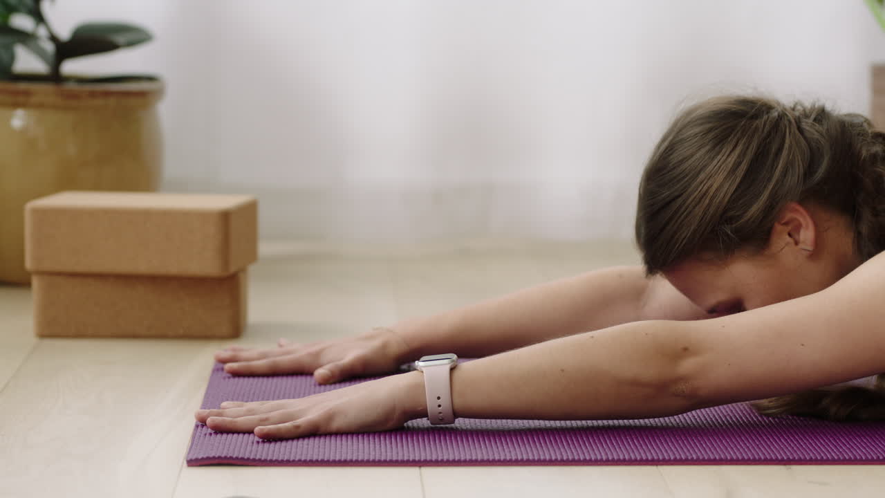 atractiva mujer de yoga ejerciendo un estilo de vida saludable practicando pose para niños disfrutando del entrenamiento en casa entrenando en una colchoneta de ejercicios