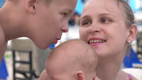 boy kissing baby sister and mom