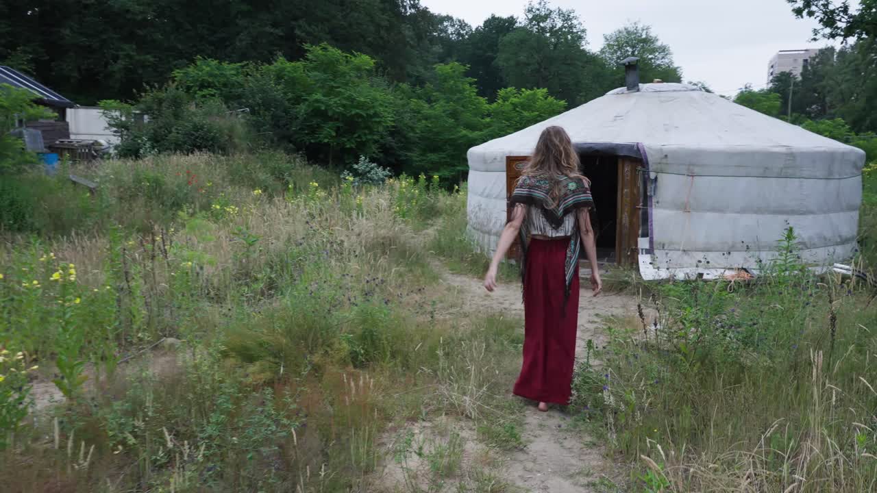 joven hippie entrando en una tienda rural en un pueblo de camping ecológico, agricultura orgánica sostenible y ecoaldea fuera de la red