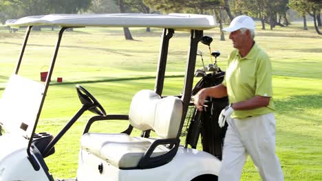 male golfer putting golf club in golf bag