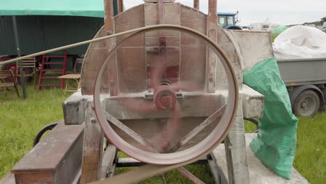 a close-up of the fast rotating belt-driven wheel of a steam driven vintage flour mill