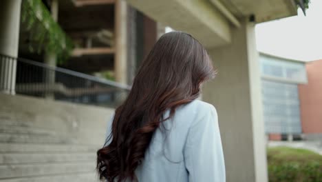 beautiful business woman walking in the corridor between the buildings at downtown. confident women walk towards their goals for success at the city.