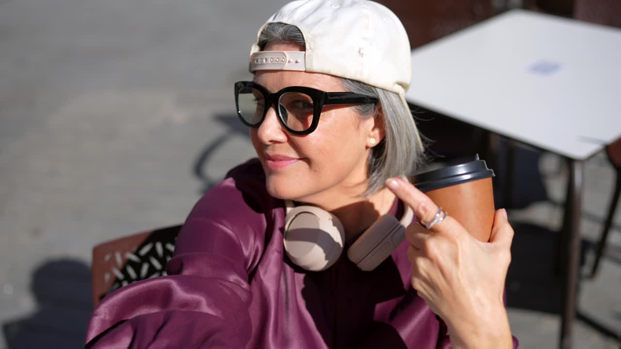Casual Woman with Headphones Drinking Coffee Outdoors