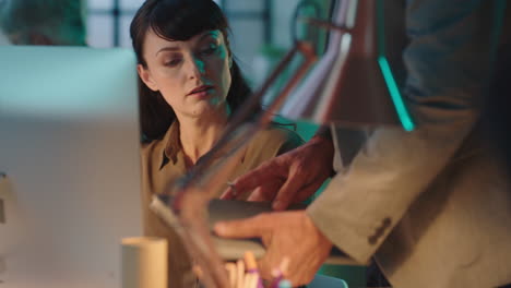 joven mujer de negocios trabajando hasta tarde usando la computadora jefe mostrando documentos equipo de oficina colaborando en el espacio de trabajo de la noche