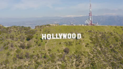 amazing aerial of hollywood sign with snowy mountains in los angeles