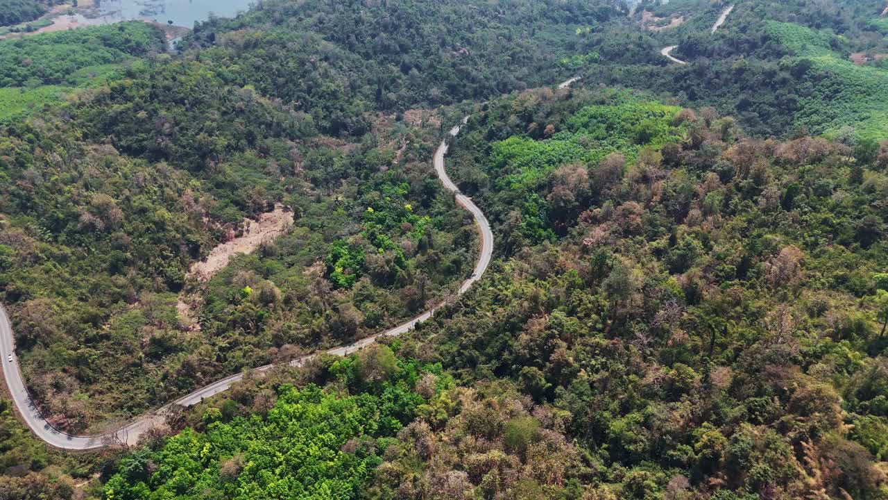 울창한 초록색으로 둘러싸인 태국 송클라부리 (songklaburi) 의 숲을 가로질러 휘어지는 도로의 조류 시각