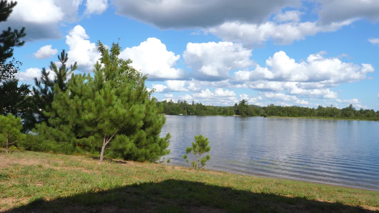 tiro estático - agua de lago ondulante de verano con cielo azul y nubes blancas hinchadas