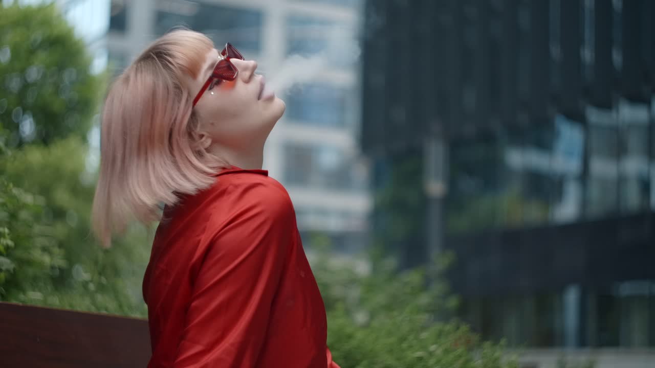 Young Woman Smoking on a City Bench