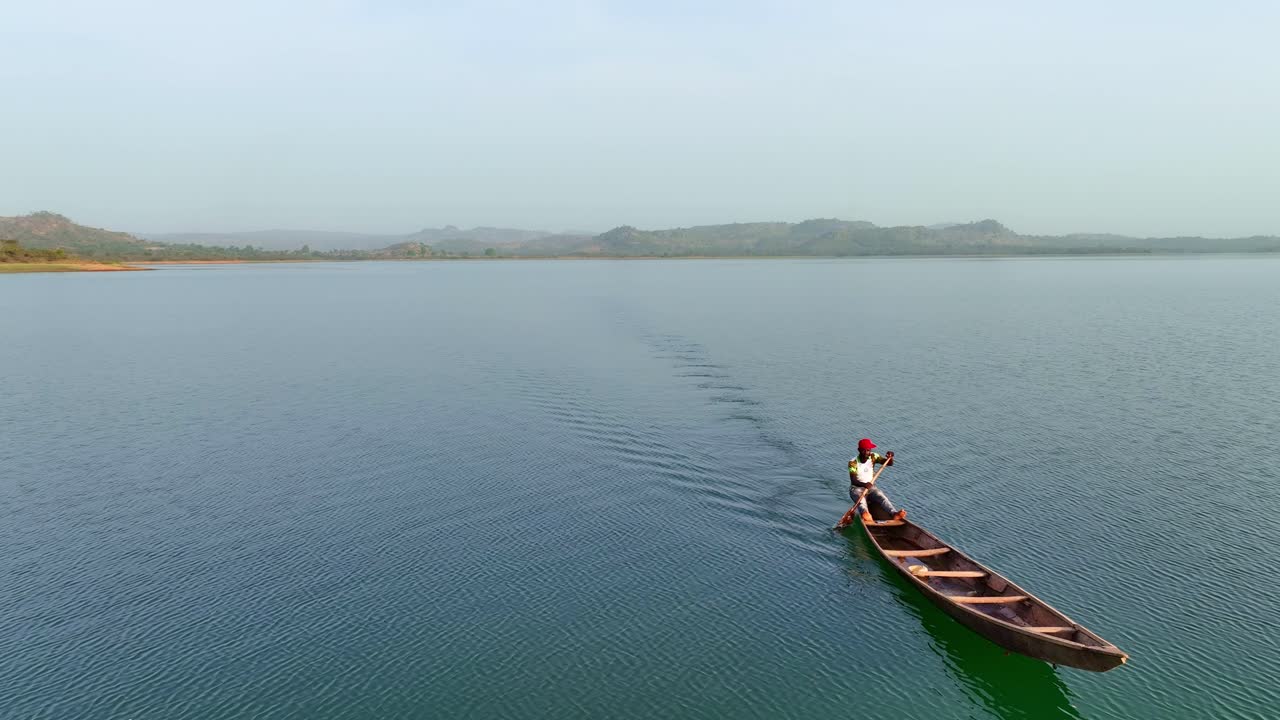 antena - toma de seguimiento de un pescador remando su canoa en el áfrica subsahariana