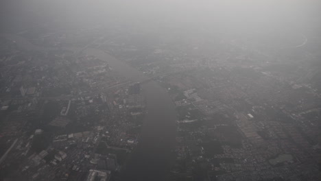 push in and pull out aerial shot of bangkok city view and the river from a flying airplane window passenger perspective