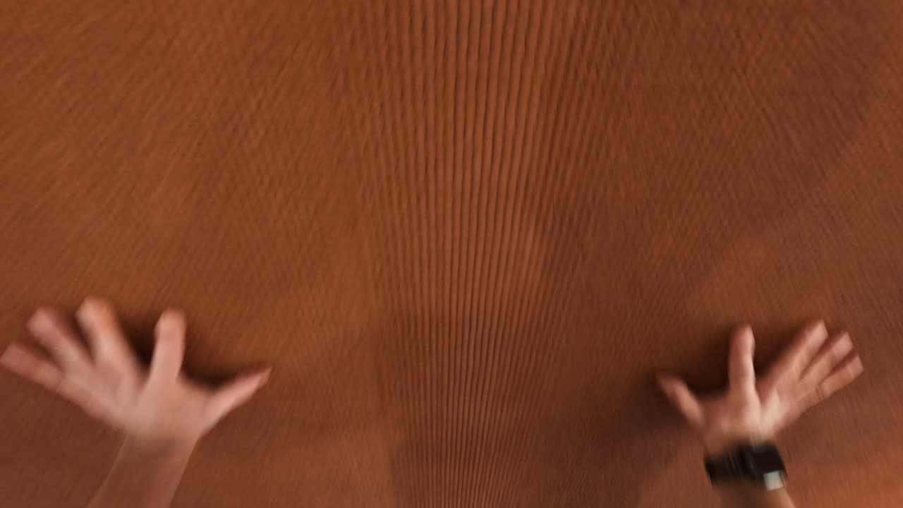 Human hands pressing against a textured brown surface, with varying degrees of blur and abstraction