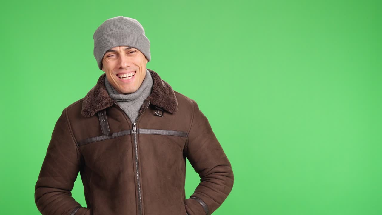 Smiling man wearing winter clothes on green screen background
