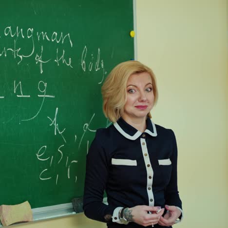 pedagogue teaches near the board. woman teacher writing on a blackboard and learning children in the classroom. education concept.
