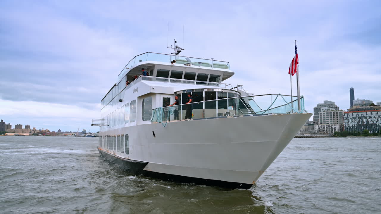 Due uomini sono in piedi a bordo di una nave da crociera a più ponti. Tour del fiume sull'East River in una giornata nuvolosa
