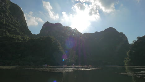 sol sobre los islotes y barco turístico navegando en la bahía de ha long vietnam