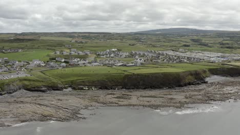 aerial rises over irish ocean cliff coast at pretty town of lahinch