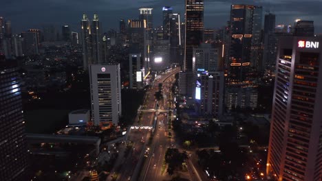 aerial tilting dolly shot of night time traffic on a busy motorway in jakarta, indonesia