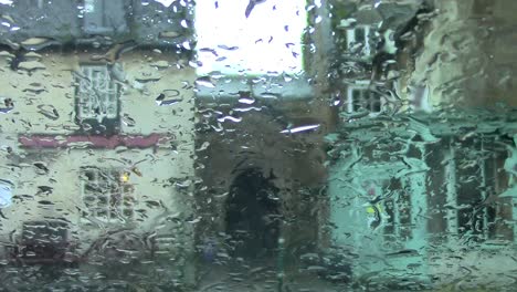 Rainfall-on-a-car-windscreen-while-parked-in-the-Market-Place-in-Uppingham,-Rutland,-England,-UK