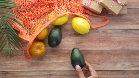 frutas en una bolsa de malla con regalos en una mesa de madera