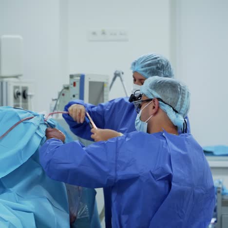 surgical process in clinic. work of surgeons on the background of medical equipment and instruments. doctor and assistant in the operating theater