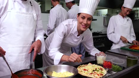 Happy-pretty-chef-preparing-a-pizza