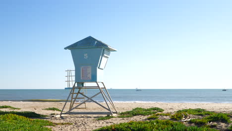 Ein-Rettungsschwimmerturm-Am-Sandstrand-Mit-Meereswellen,-Die-In-Zeitlupe-Am-Ufer-In-Santa-Barbara,-Kalifornien,-Zusammenbrechen