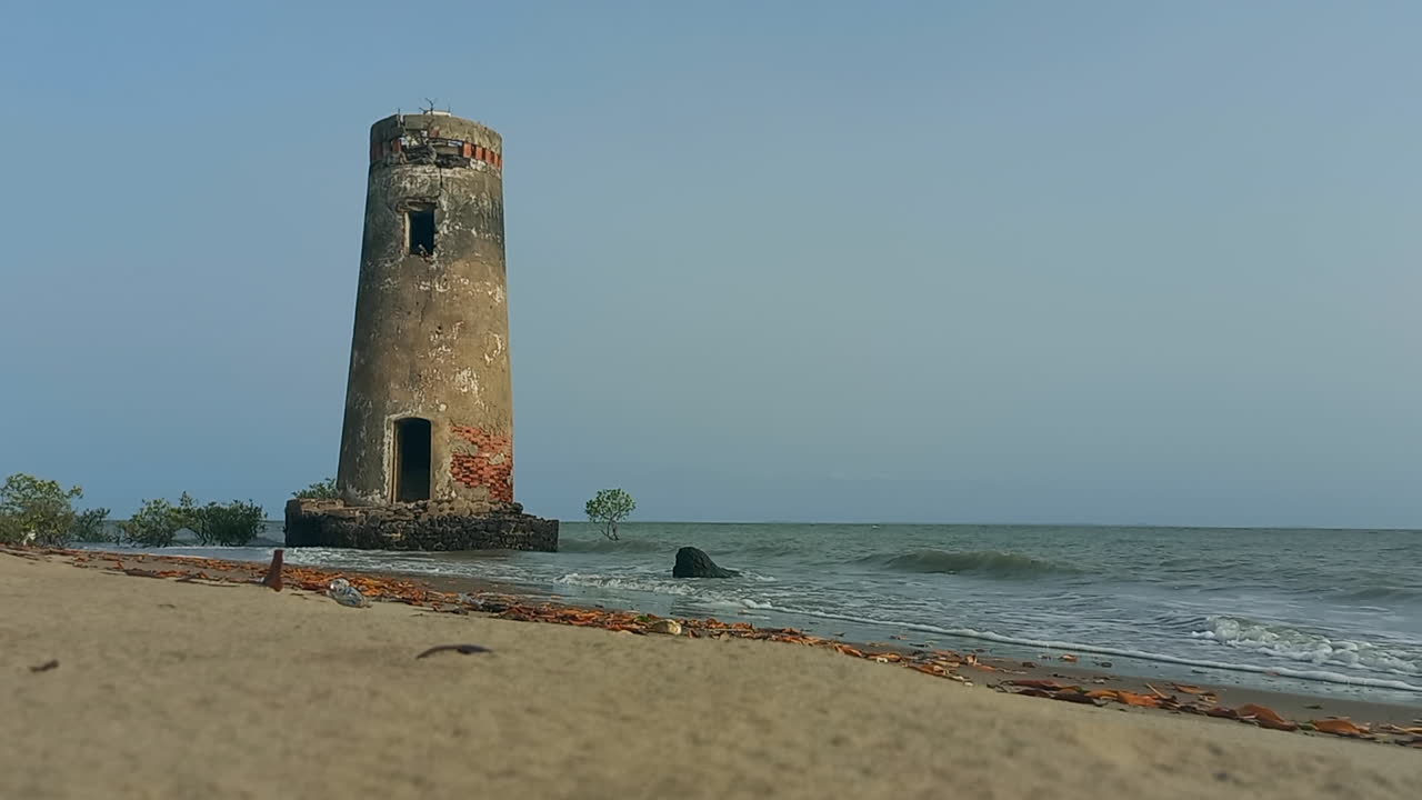 torre de un pequeño faro destruido en la playa