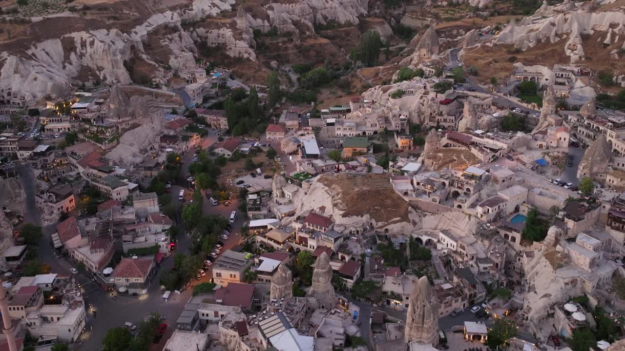 Carrellata aerea al tramonto con l'ultima luce che si posa su una città scavata nella roccia nella valle, Cappadocia Turchia