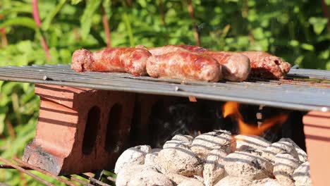 Würstchen,-Die-Auf-Dem-Grill-über-Heißen-Kohlen-Brutzeln