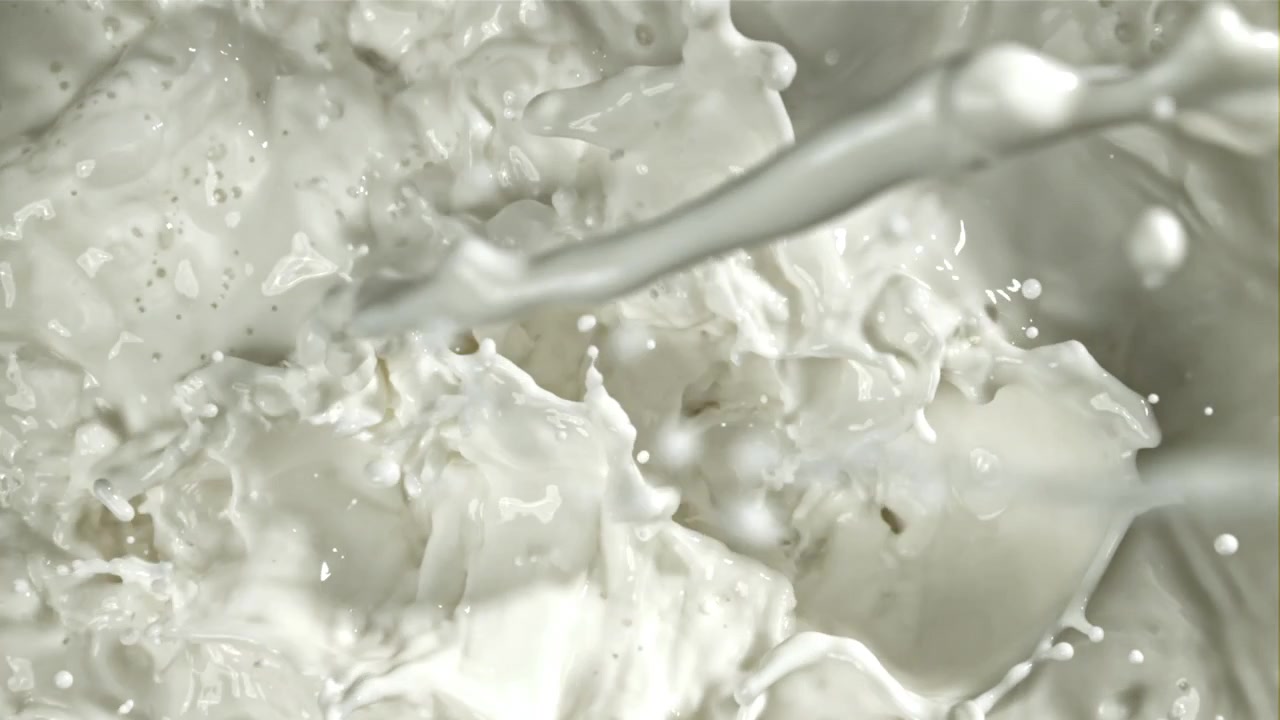 Latte bianco fresco che si versa e schizza al rallentatore